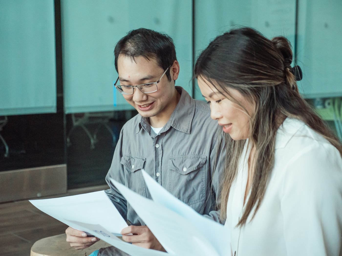 Two colleagues reading through printed documents together